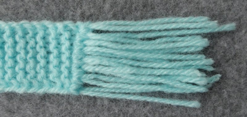 Blog-Inhaltsbild für 'Schal und Mütze für kleine Modepuppen - Kostenlose Strickanleitung'