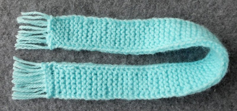 Blog-Inhaltsbild für 'Schal und Mütze für kleine Modepuppen - Kostenlose Strickanleitung'