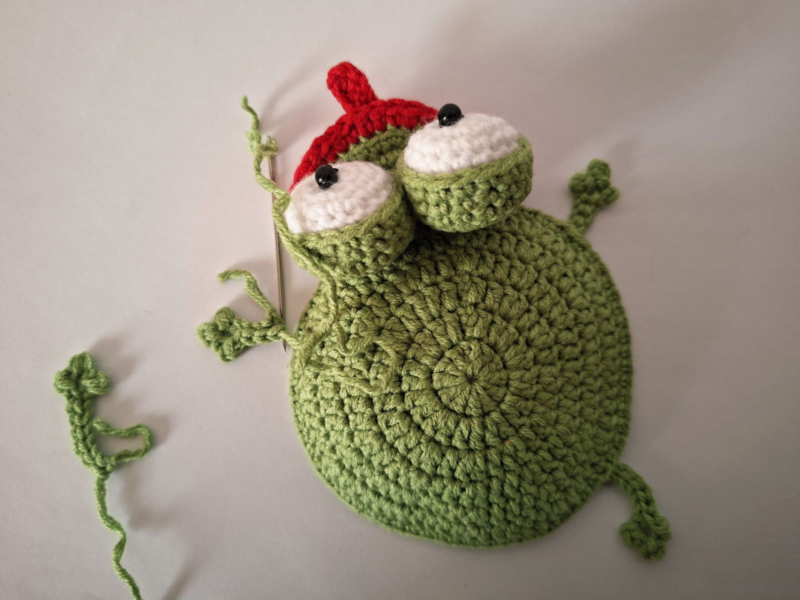 Blog-Inhaltsbild für 'Frosch mit Beuteltasche häkeln. Kostenlose Häkelanleitung'
