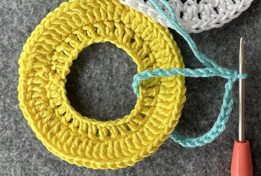 Blog-Inhaltsbild für 'Dekorativer Anhänger aus bunten Garnresten - Kostenlose Häkelanleitung'