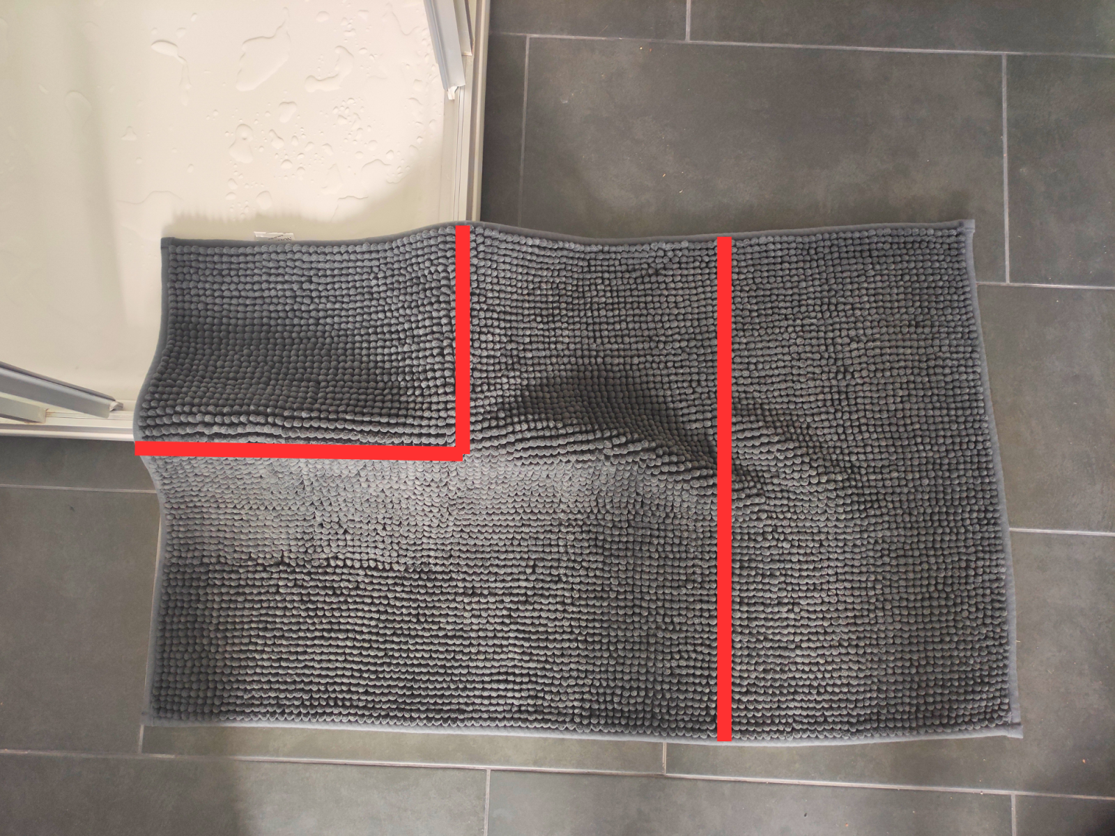 Blog-Inhaltsbild für 'DIY: Aus einem normalen Badteppich wird ein V‑förmiger Teppich für die Eckdusche'