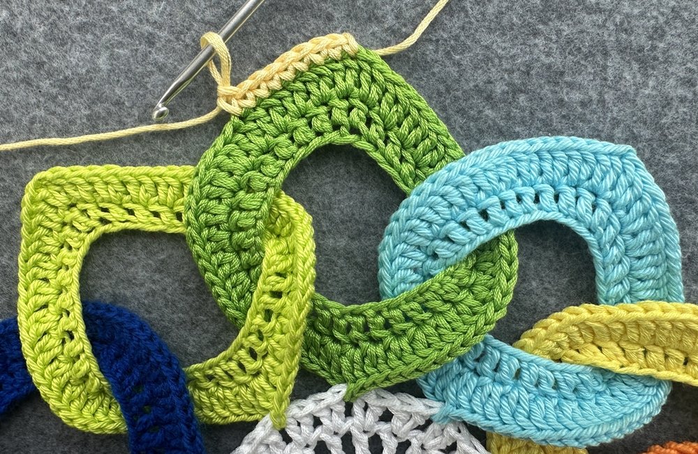 Blog-Inhaltsbild für 'Dekorativer Anhänger aus bunten Garnresten - Kostenlose Häkelanleitung'