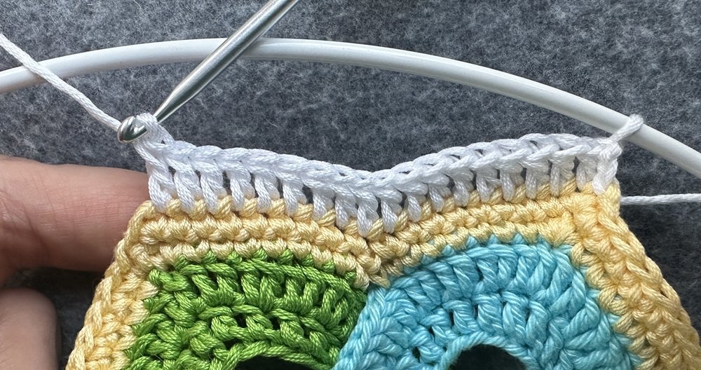 Blog-Inhaltsbild für 'Dekorativer Anhänger aus bunten Garnresten - Kostenlose Häkelanleitung'