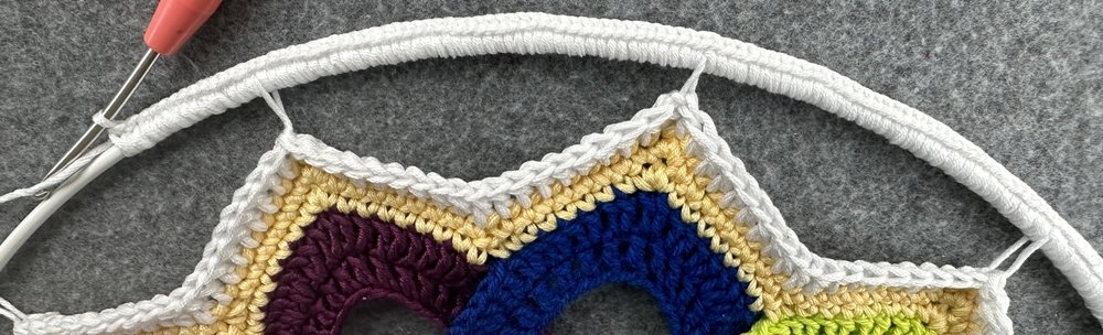 Blog-Inhaltsbild für 'Dekorativer Anhänger aus bunten Garnresten - Kostenlose Häkelanleitung'