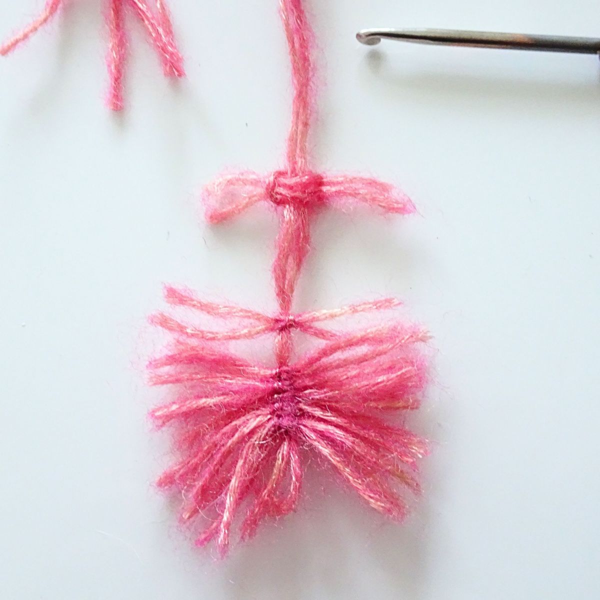 Blog-Inhaltsbild für 'Gehäkelte und geknüpfte Woll-Federn – 2 kostenlose Anleitungen für Handarbeits-Projekte, z.B. Ostereier-Deko'