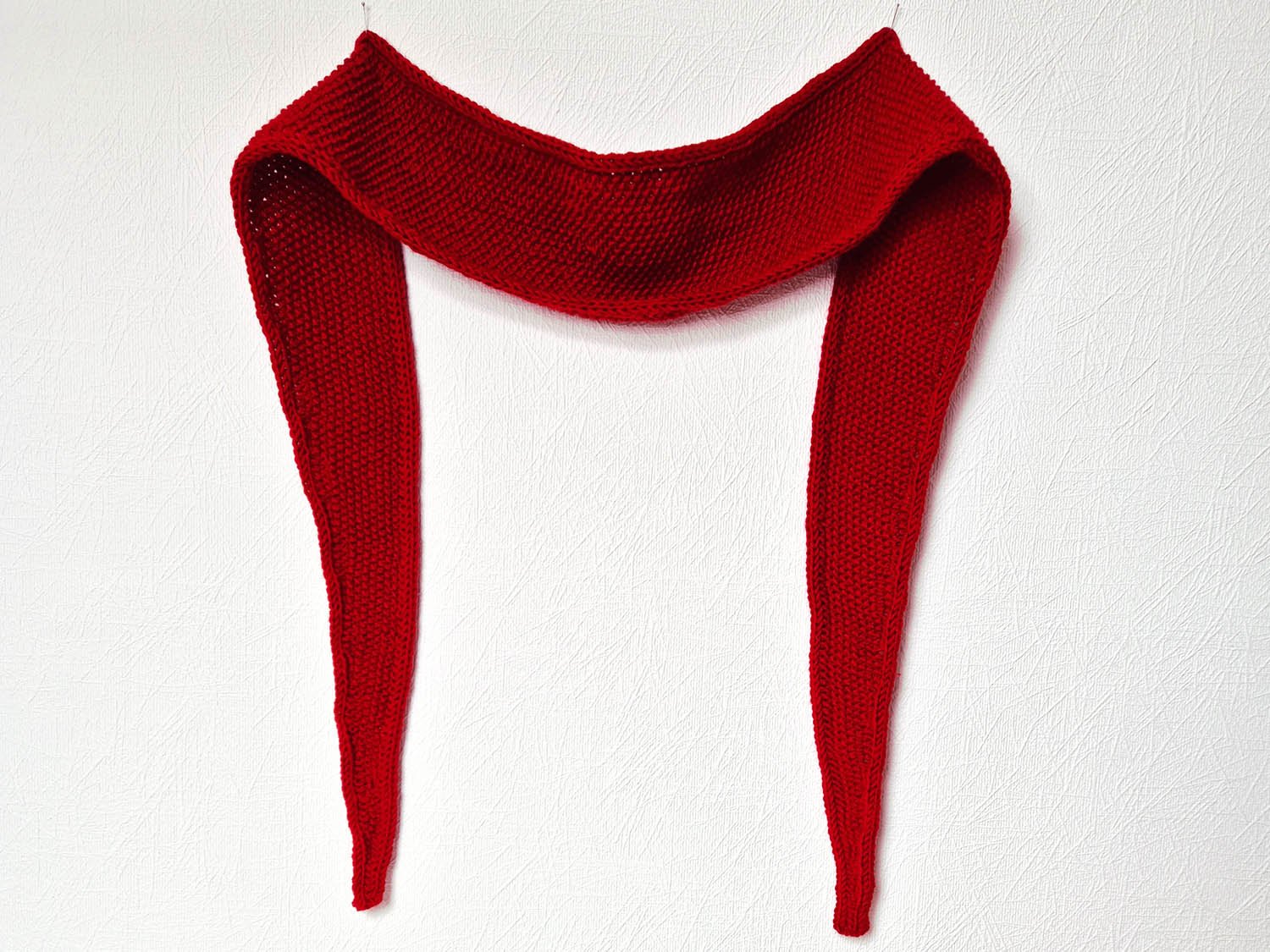 Ein rotes Tuch hängt an der Wand und ist mit 2 Stecknadeln angesteckt.