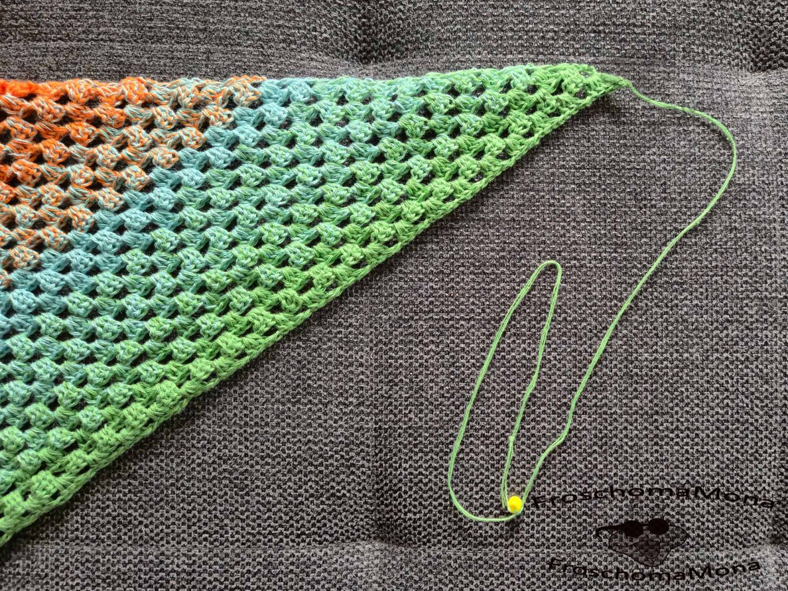 Das Bild zeigt ein Stück des Häkeltuches Blätterzauber und den Garnrest, der nach dem Häkeln der letzten Reihe übrig war.