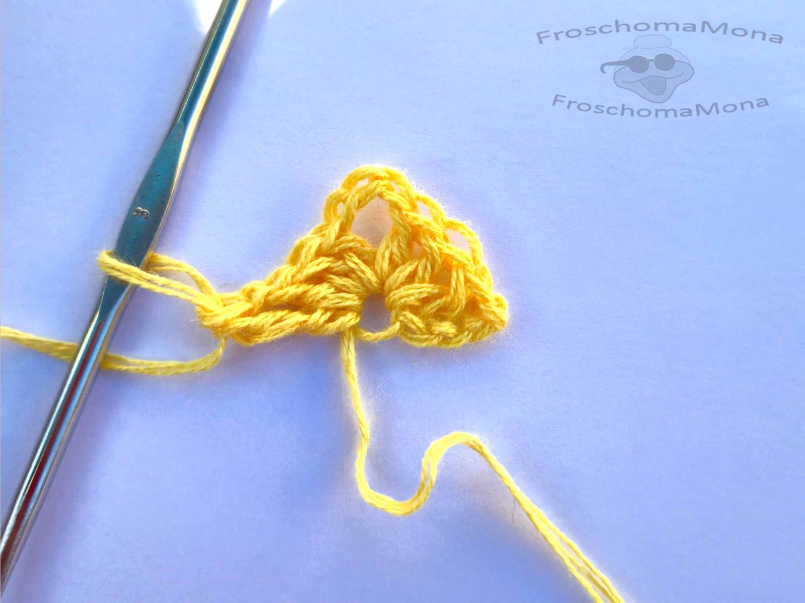 Der Start des Tuches wird gezeigt, gehäkelt mit gelber Wolle.