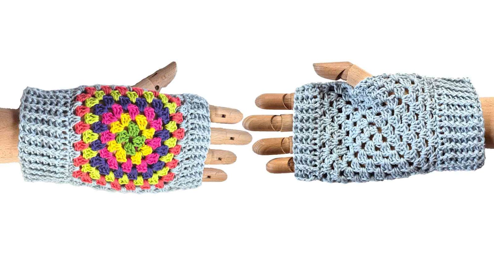 Nocheinmal ein Bild mit den fertigen Handstulpen, einmal zu sehen die einfarbige Seite und einmal die kunterbunte Seite. Beide Handstulpen befinden sich wieder auf einer Hand aus Holz.