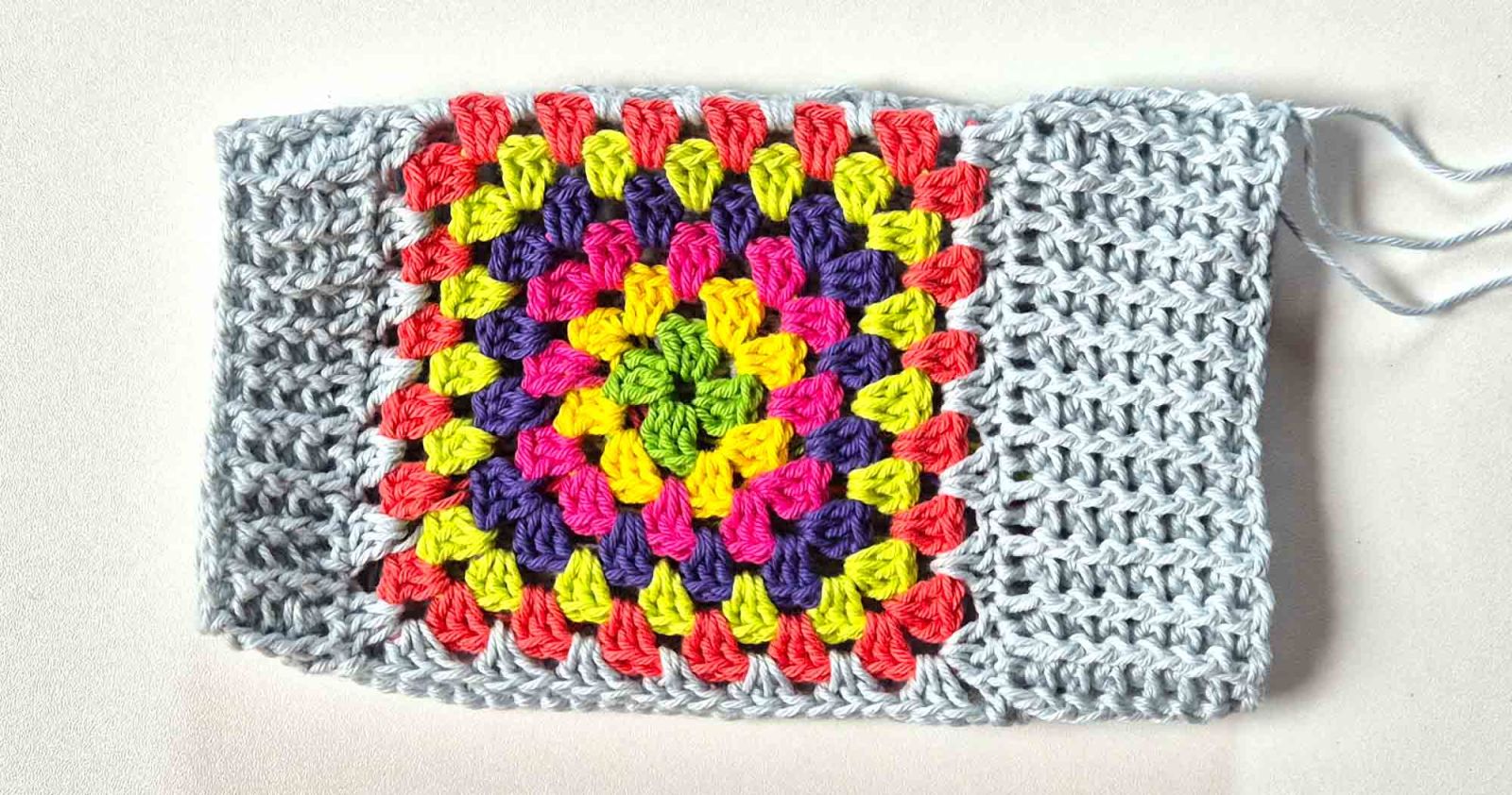 Die Handstulpe mit Bündchen auf beiden Seiten ist zu sehen. Obenauf die kunterbunte Seite.