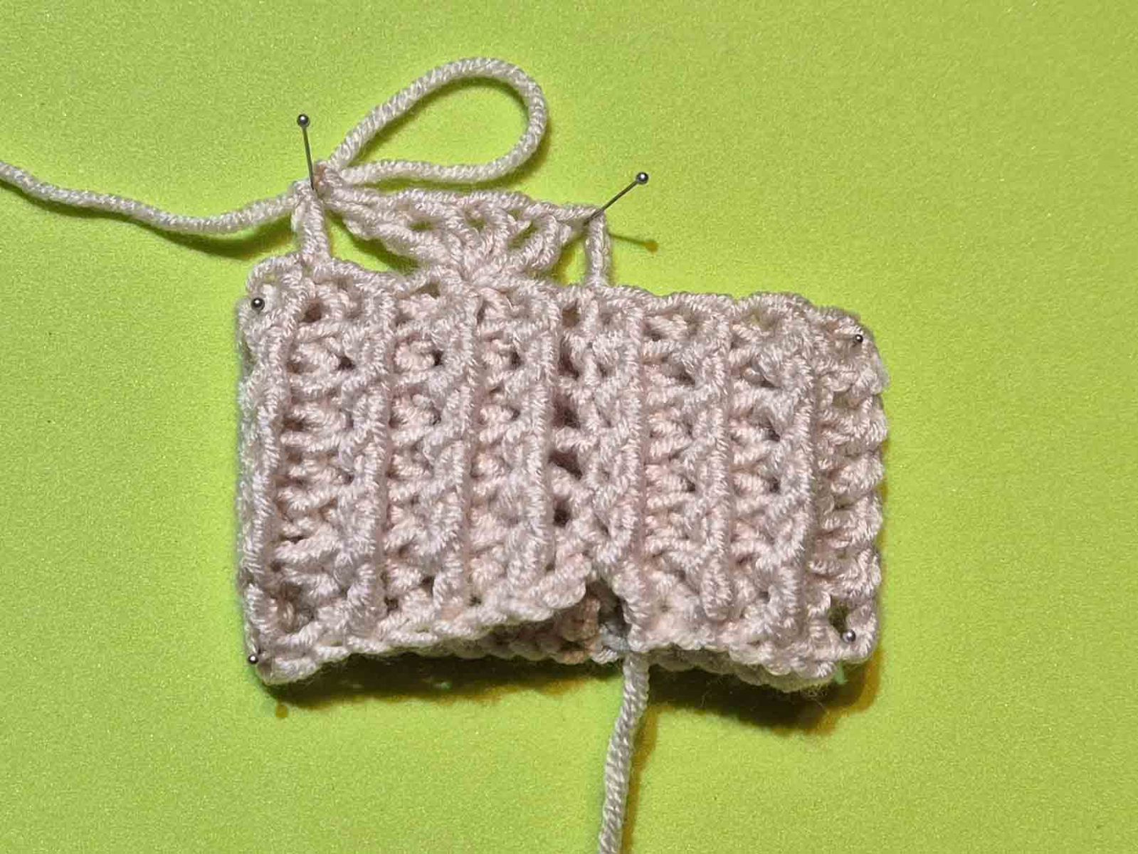 Das Bild zeigt das fertige Armbündchen und den Beginn des Muschelmusters.