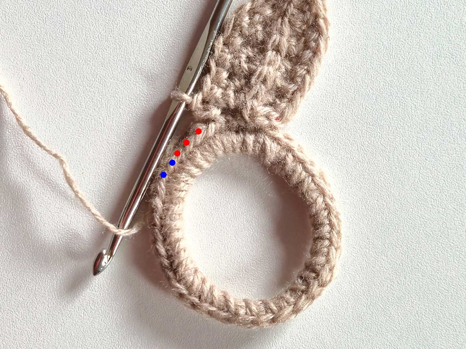 Das Bild zeigt farbig in rot und blau gekennzeichnet die Einstichstellen für die nächsten Maschen.