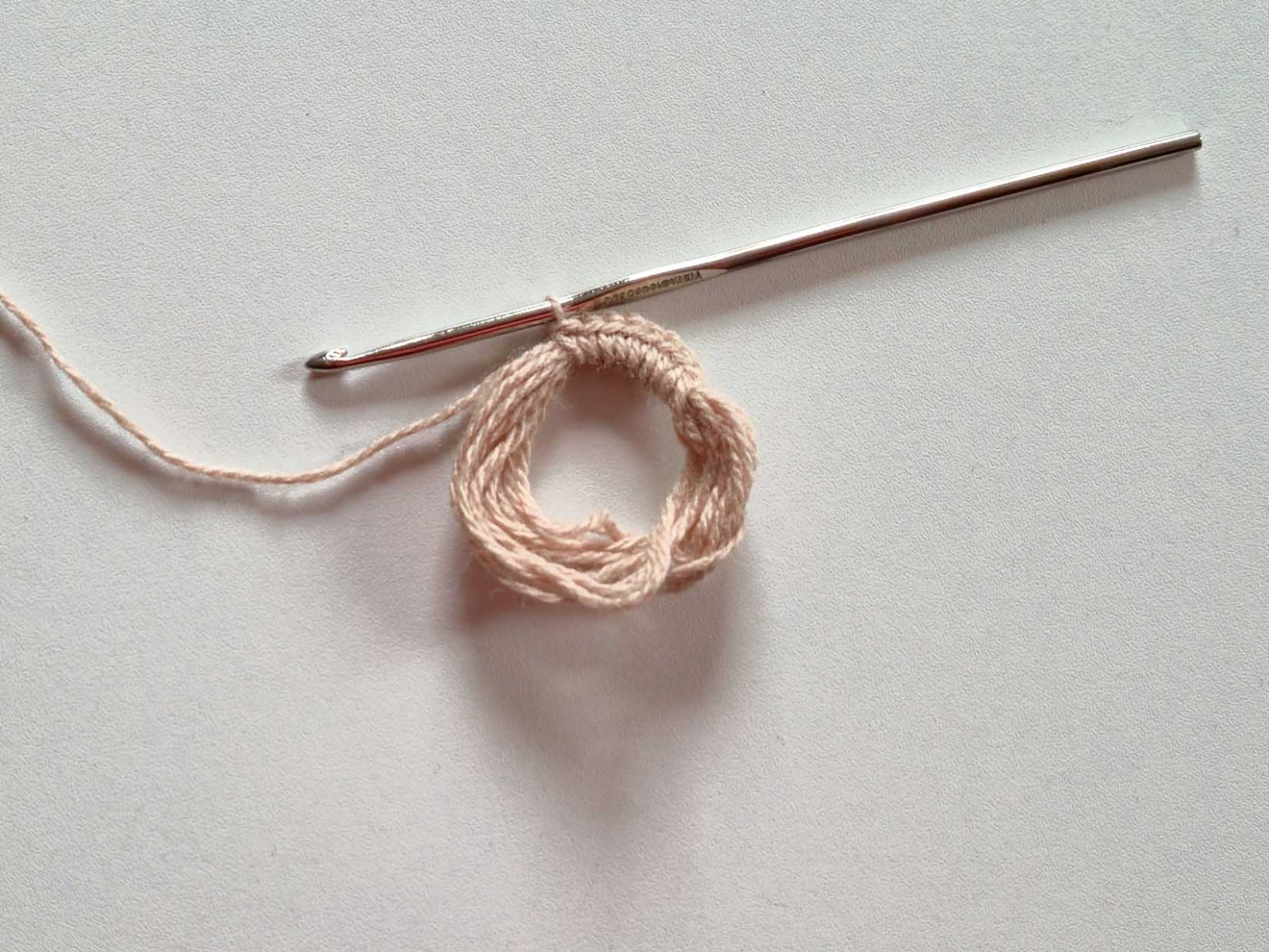 Ein Ring, gewickelt aus mehreren Runden beigem Garn wurde mit mehreren festen Maschen begonnen zu umhäkeln..