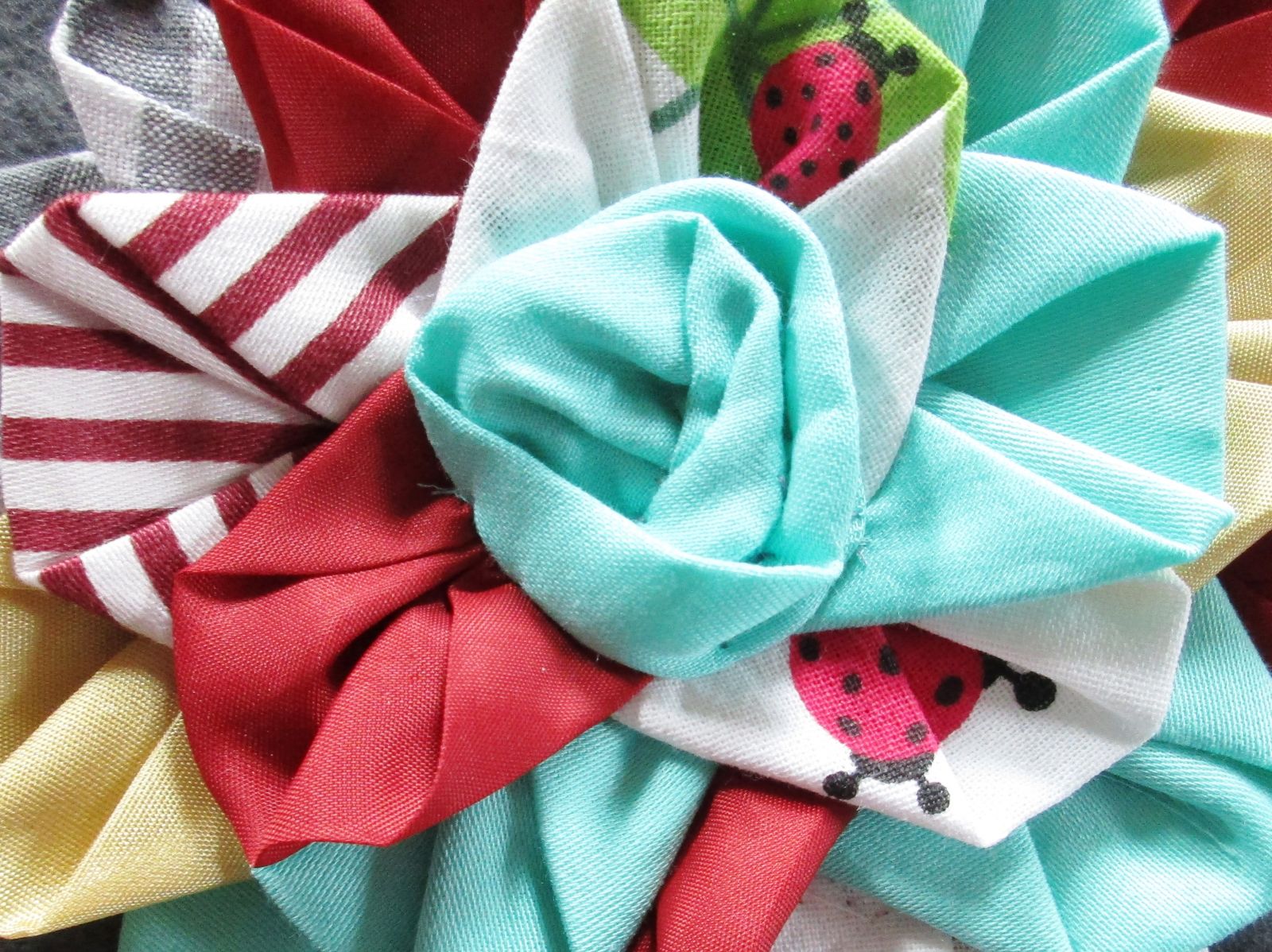 Blog-Inhaltsbild für 'Blüten Applikation aus Stoffresten nähen Upcycling Projekt: Blumen Applis für Kissen, Pullis oder Taschen im Origami Style'