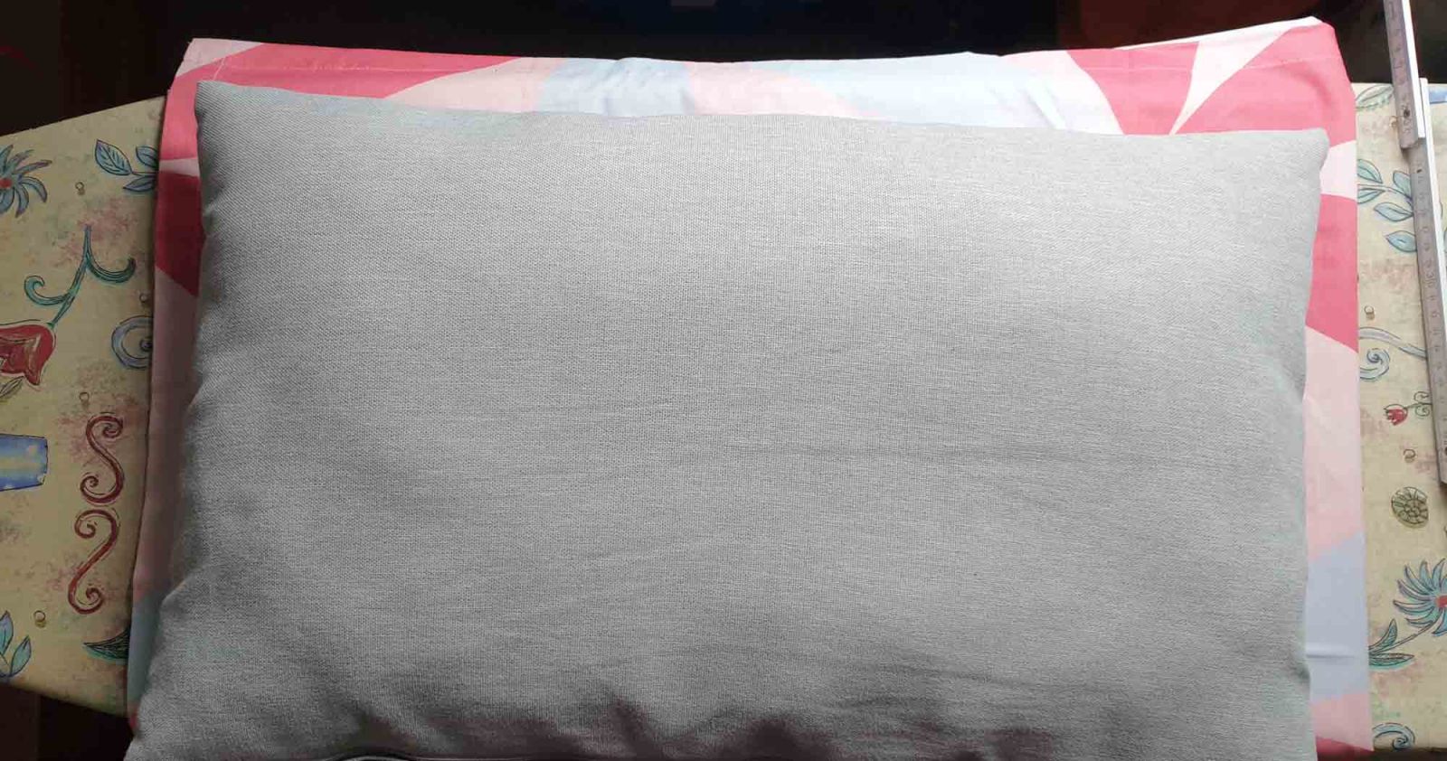 Das zu beziehende Kissen liegt auf dem Stoff zur Probe, ob der Stoffrest ausreicht.