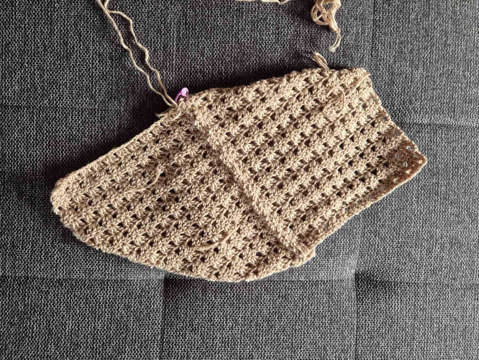 Die Kanten des beigen Häkelstückes, die aneinander stoßen, sind nun zusammengehäekt.