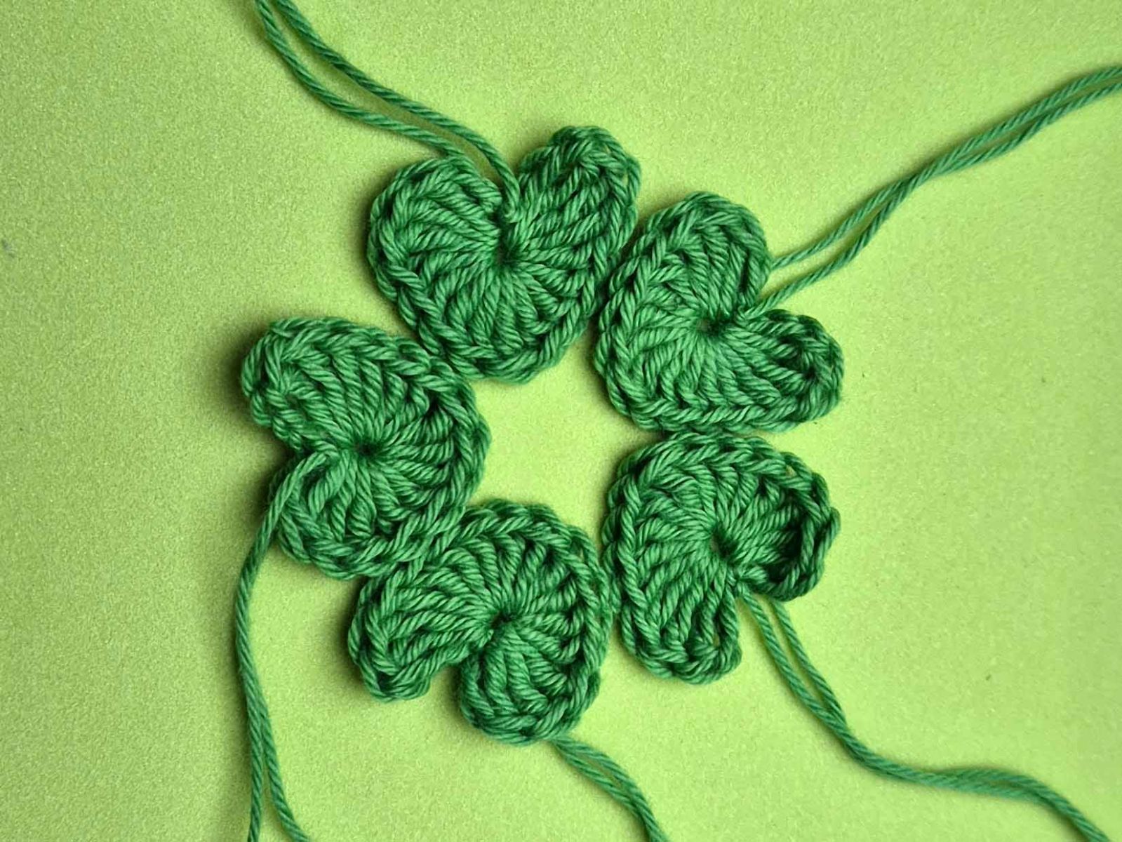 Fünf gehäkelte Herzen wurden zu einem Fünfkleeblatt gelegt.