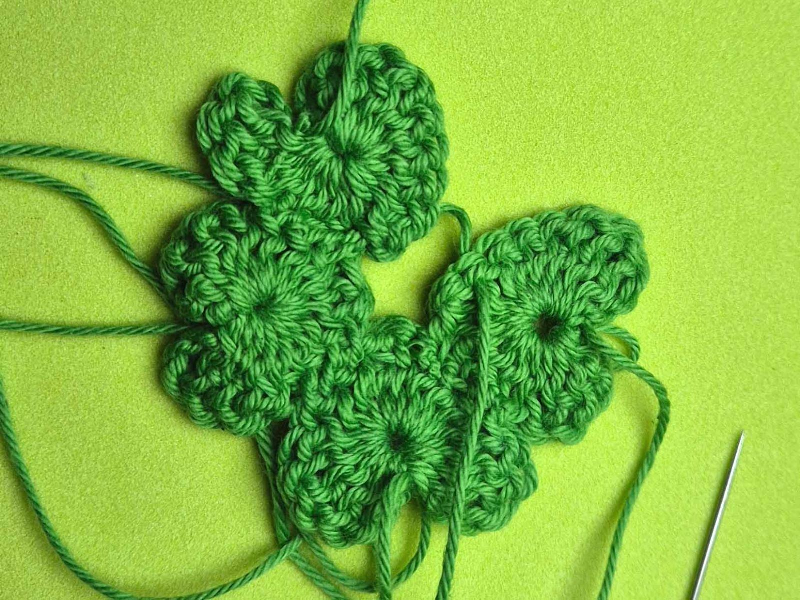 Vier gehäkelte Herzen werden aneinander genäht.