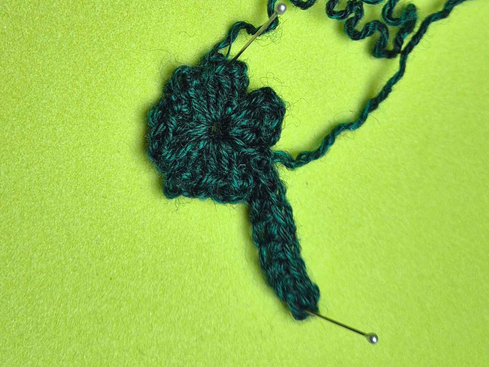 Das fertig gehäkelte Kleeblatt wird gezeigt. Die Fäden sind noch nicht vernäht.