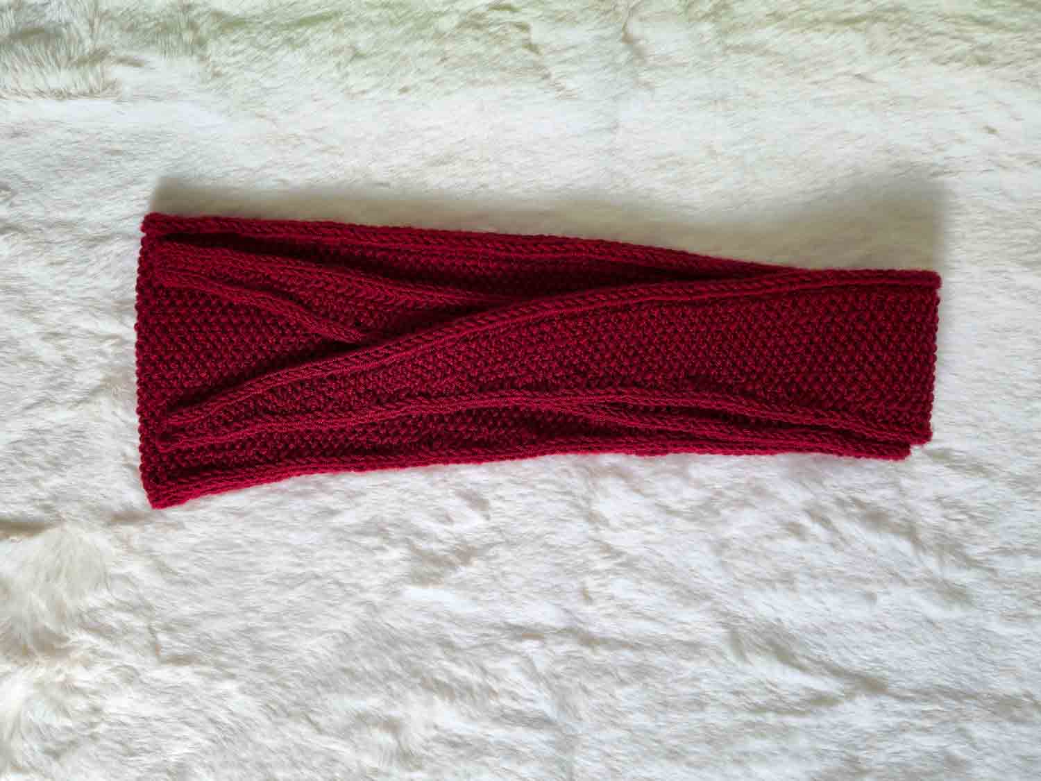 Ein rotes Tuch liegt zusammengefaltet auf einem hellen Fell.