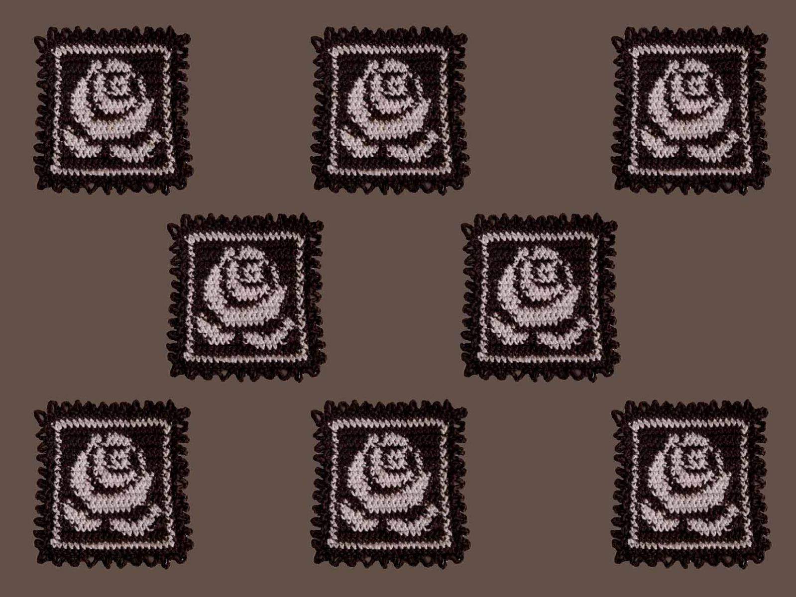 auf einem braunen Untergrund liegen 8 gehäkelte Rosen in Briefmarkenform