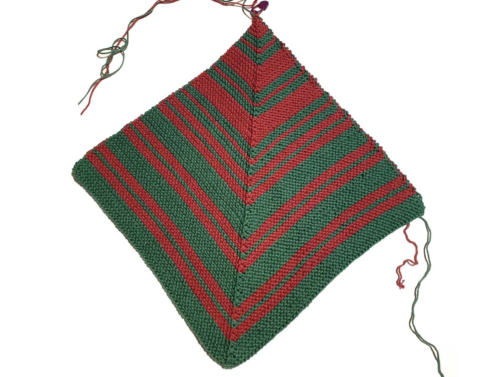 Der fertig gestrickte Topflappen in den farben Grün und Weinrot ist zu sehen.