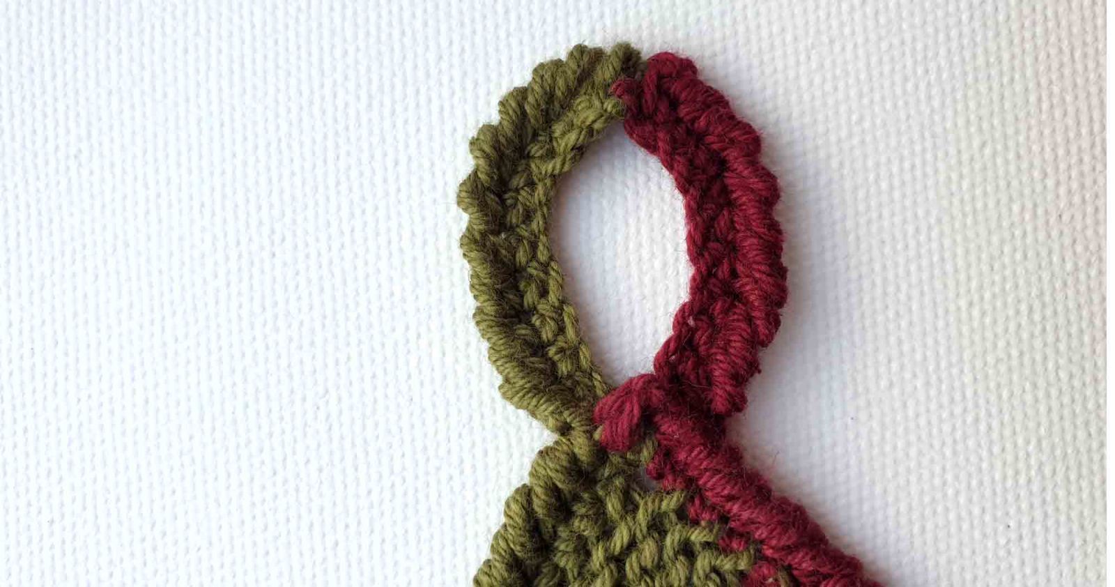 Der fertige Aufhänger in den Farben grün und weinrot ist fertig gehäkelt.