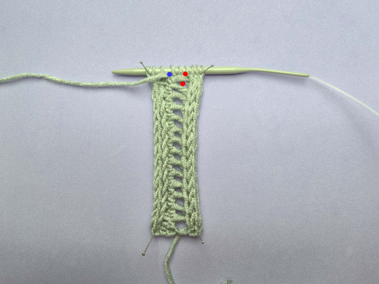 Gleiches Bild, jetzt mit rot gekennzeichnet die letzten beiden Löcher der ersten Lochreihe und in blau gekennzeichnet das erste Loch der neu entstehenden Lochreihe.