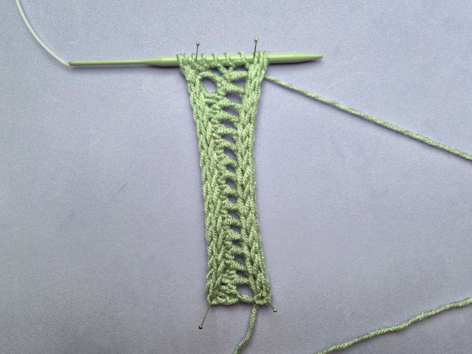 Strickstück nach Reihe 32. Das zweite Loch der zweiten Lochreihe ist entstanden.