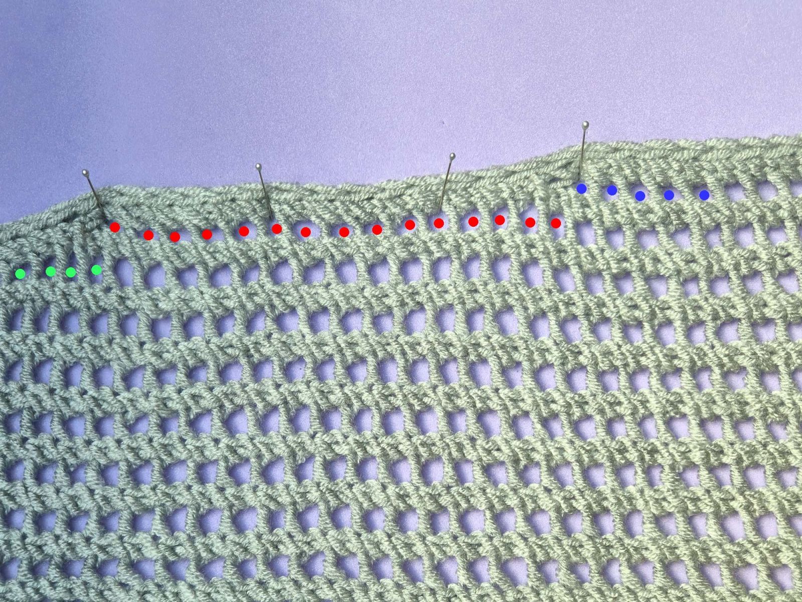 Die Tuchmitte mit den ersten Abnahmen ist zu sehen. Zur Verdeutlichung sind die verschiedenen Lochreihen wieder blau, rot und grün markiert.