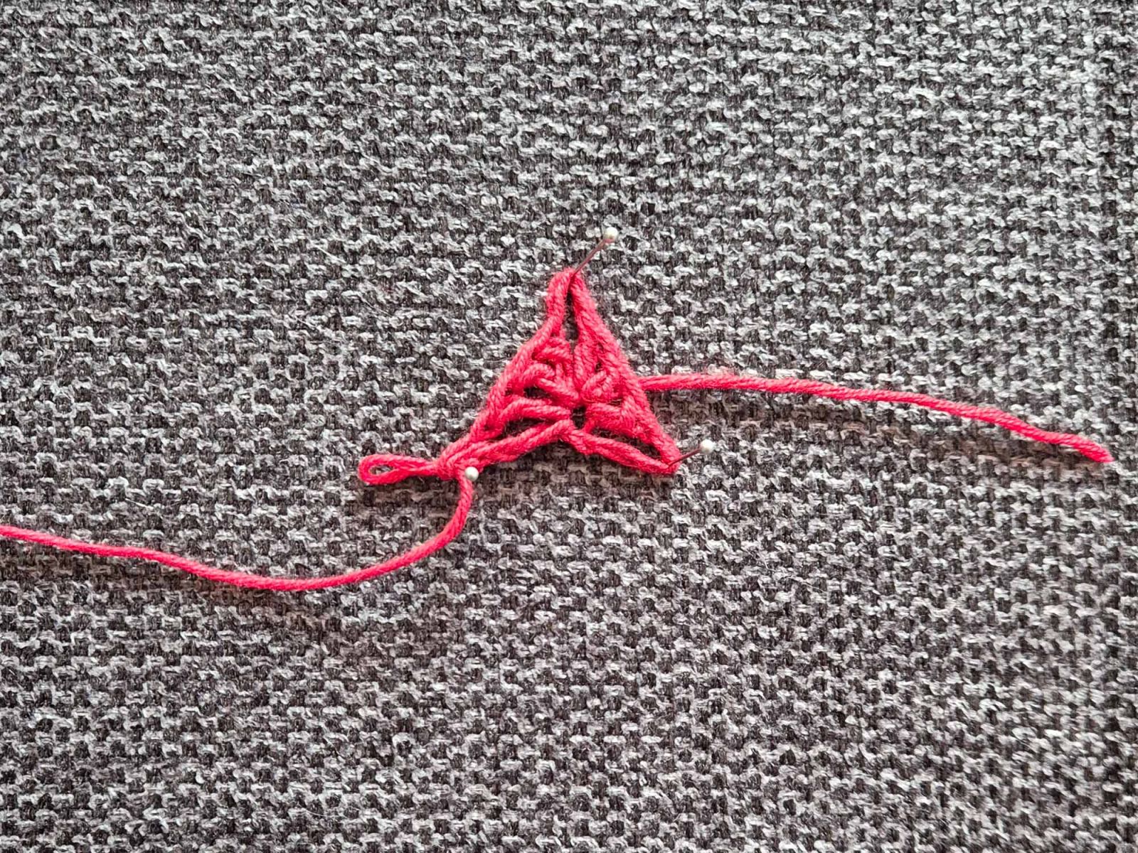 Nach dem Häkeln der ersten Reihe wurde das Häkelstück mit Stecknadeln auf einem Untergrund angesteckt zur Verdeutlichung der Maschen.
