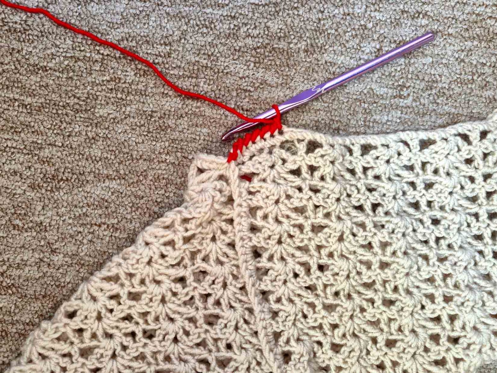 Das Bild zeigt die ersten Maschen der Umrandung mit roten Krebsmaschen.