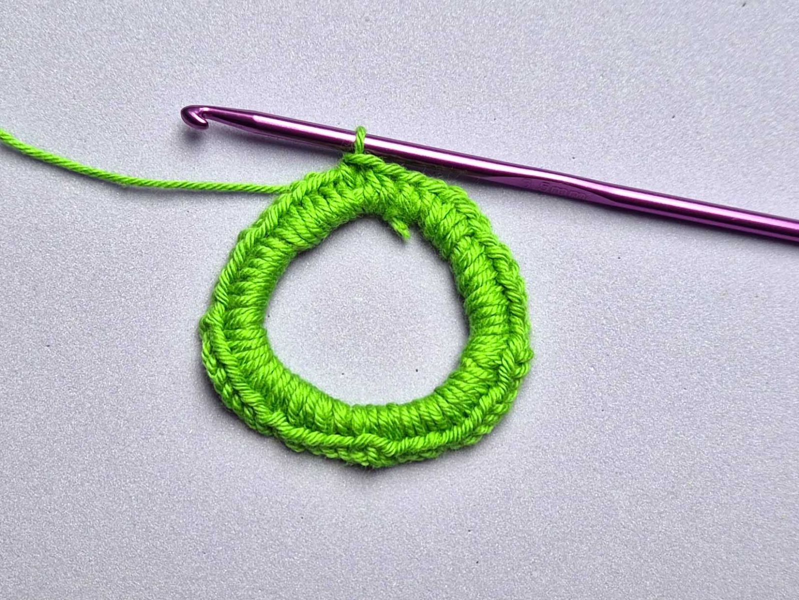 Der Ring aus grünen Fäden wurde vollständig mit 54 festen Maschen umhäkelt.