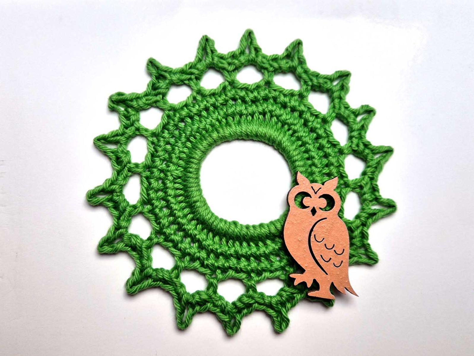 Das grüne Häkelstück wurde mit einer kleinen Eule aus Holz dekoriert.