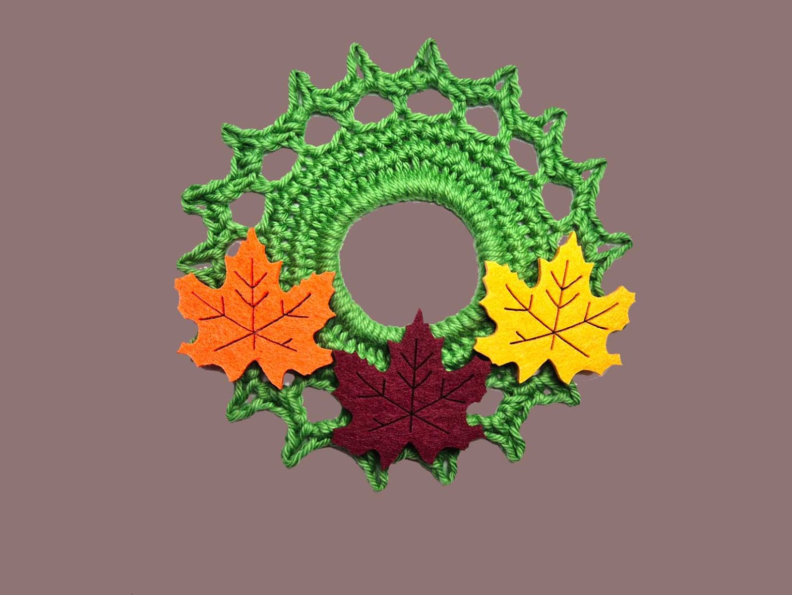 Das fertige grüne Häkelstück wurde mit 3 Ahornblättern aus Filz dekoriert.