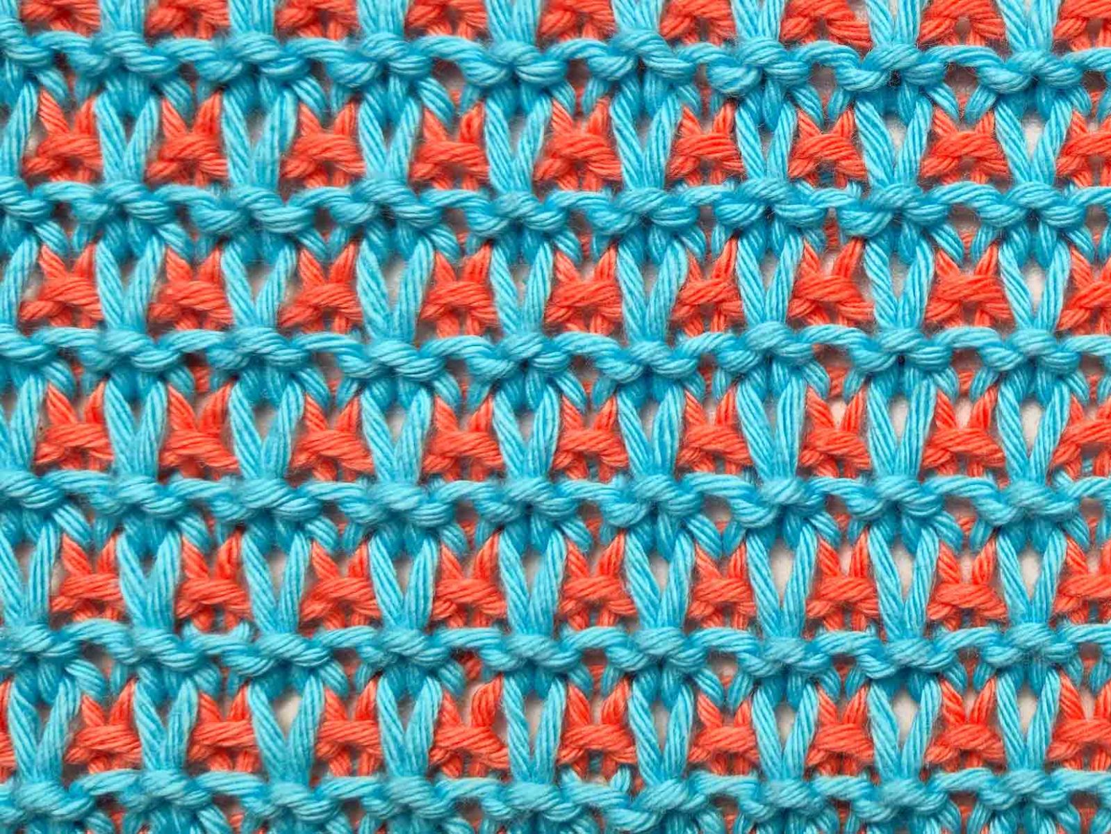 Das Bild zeigt die zweifarbig gestrickte Vorderseite des Topflappens.
