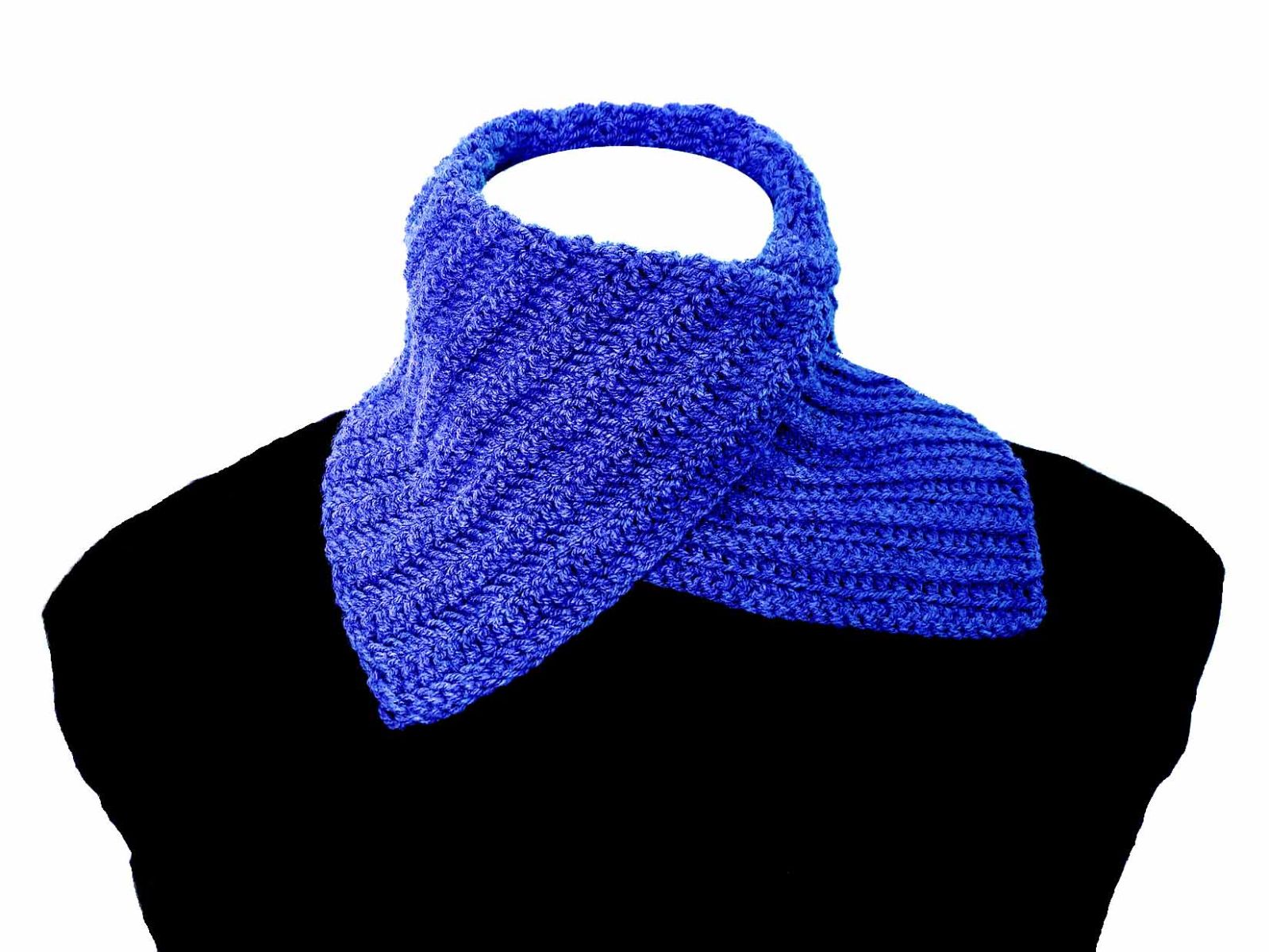 Ein gehäkelter blauer Klapschal wurde einer Schaufensterpuppe ohne Kopf angezogen.