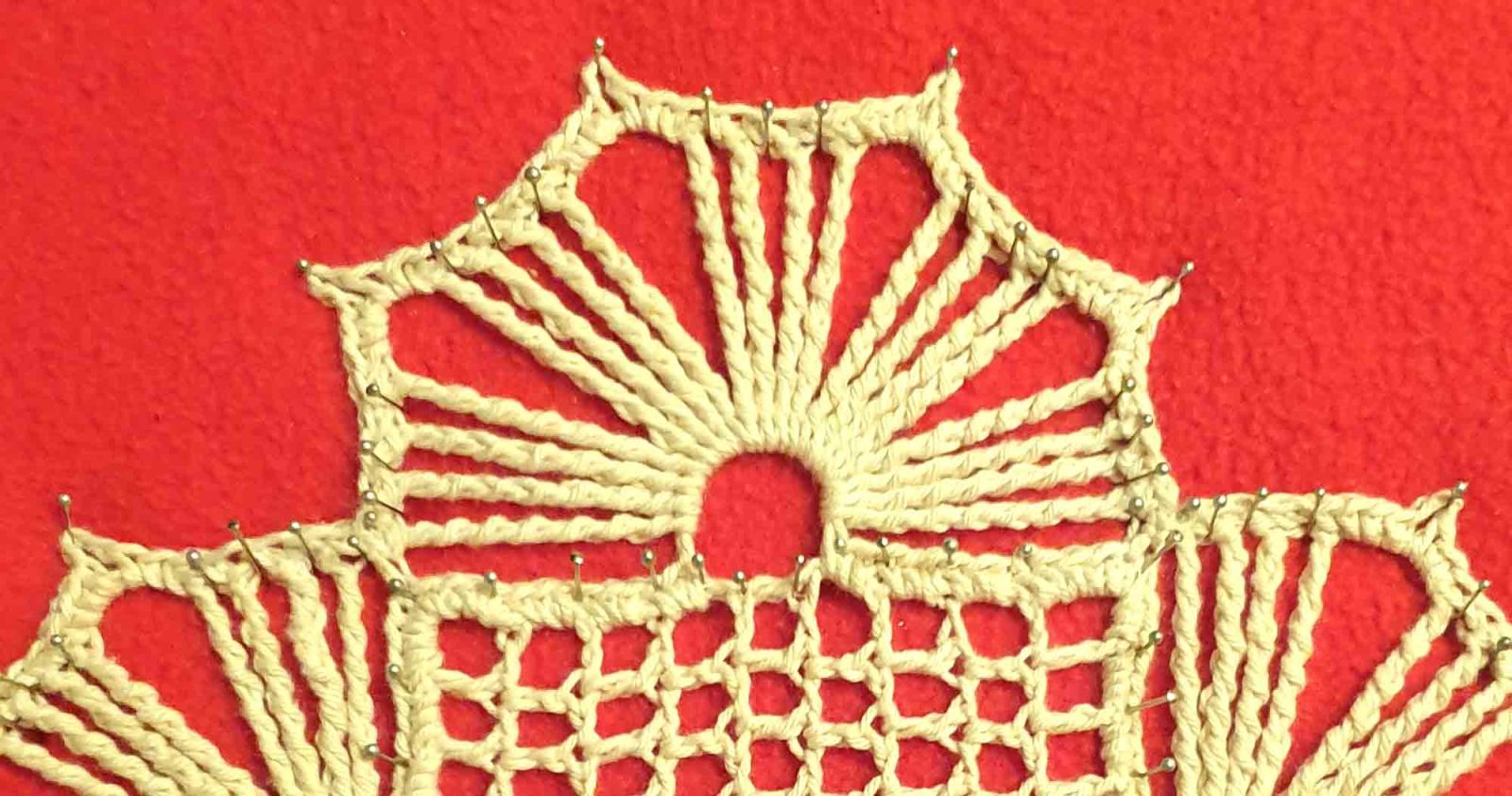 Ein Ausschnitt des festgesteckten Deckchens wird vergrößert gezeigt.