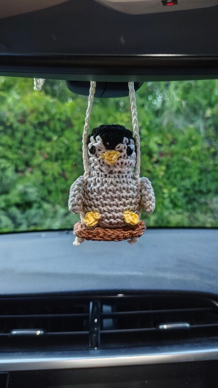 Kleiner Pinguin auf Schaukel