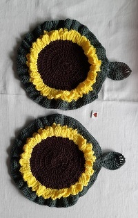 Es hat gut geklappt, habe das Muster aber individuell erweitert, d.h. 4x die Sonnenblume gehäkelt und dann je 2 zusammengenäht. Aufhänger in Blattform dazu genommen und die Topflappen größer, d.h. mit einem  Durchmesser von ca. 25 cm, gehäkelt.