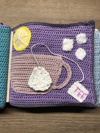 Teetasse mit Teebeutel und Zuckerstückchen auf Klettpads - die Tasse ist oben offen, so dass sich Teebeutel und Zucker einfüllen lasse