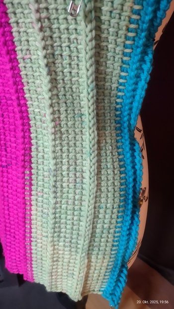 Nachdem ich die Anleitung vor Jahren gekauft hatte, verweilte sie unberührt auf dem Laptop. Ich habe mehrere Versuche gestartet und nun mit größerer Nadel und nach jeder 5. Reihe eine Reihe Perlstich gearbeitet. Leider rollt es sich immer noch ein bisschen. Da ich absoluter Neuling bin, was tunesisch Häkeln angeht, habe ich dafür auch noch keine Lösung gefunden. Nach mehreren Anläufen habe ich es allerdings hinbekommen mittels einer Reihe Kettmaschen (in das senkrechte Maschenglied des Grundstichs, in der Rückreihe von unten in das hintere Maschenglied wieder eine Reihe Kettmaschen häkeln, in der nächsten Hinreihe von oben in das hintere Maschenglied den tunesischen Grundstich arbeiten) eine schöne Verbindung zu arbeiten. Sieht aus wie ein eingerahmter Perlstich. Bin richtig stolz auf mich, weil es totaler Zufall war. Vielleicht gefällt es ja der ein oder anderen. Kein Zusammenhäkeln und kein Zusammennähen. Es ließ sich so ohne Probleme das Armloch arbeiten.