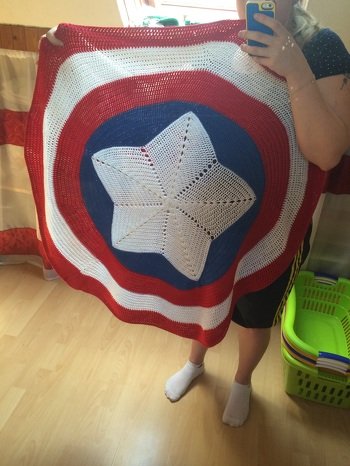Gehäkelte Decke aus Merino mit über 1m Durchmesser fürs Söhnchen. Vorbild war das Schild von Marvels Captain America. In der Mitte nach esbelottas Anleitung für einen Stern. Die Zackenzwischenräume sind durch reines Probieren passend eingearbeitet worden. Die Runden in rot und weiß sind mit Zunahmen nach Gefühl gearbeitet.