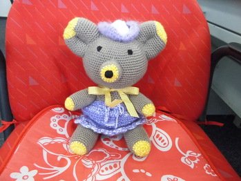 teddy für den kindergarten sitzt ganz bequem auf dem stuhl mit röckchen und hütchen