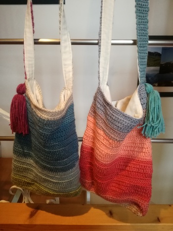 Taschen aus Verlaufsgarn, geschmückt mit einer Quaste. Da die Tasche sich etwas durchhängt, habe ich sie mit Stoff ausgekleidet.