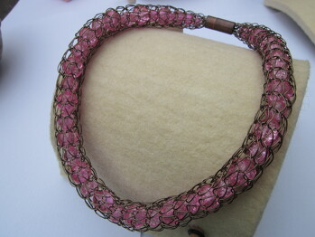 Viking knit
handgestrickter Schlauch aus lackiertem Kupferdraht, gefüllt mit rosa Glascrashperlen