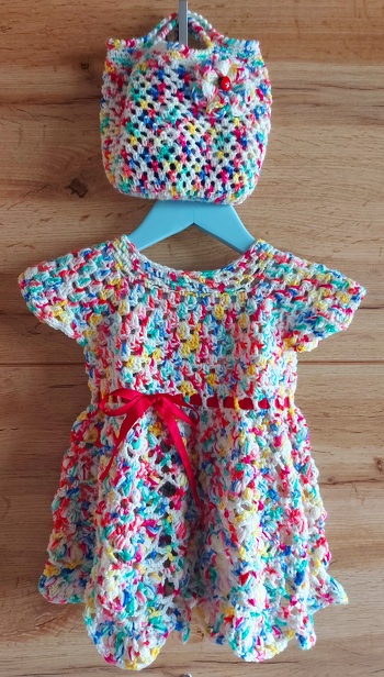 Dieses lustig bunte Kleid samt praktischer Netztasche ist aus Acrylgarn gehäkelt. Ich schätze es auf Gr.80.