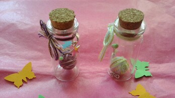 Minifläschchen mit Miniknäuel mit Stecknadeln als Stricknadeln