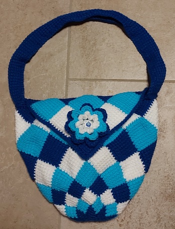 Diese Tasche habe ich aus Megaball Aran von Hobbii mit NS 5 tunesisch in Entrelac-Technik gehäkelt. Magnetverschluß und Blümchen dran.