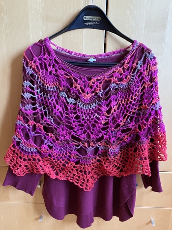 Schulterwärmer aus bunter Sockenwolle, er ist im Kreis gehäkelt, wie ein Poncho.